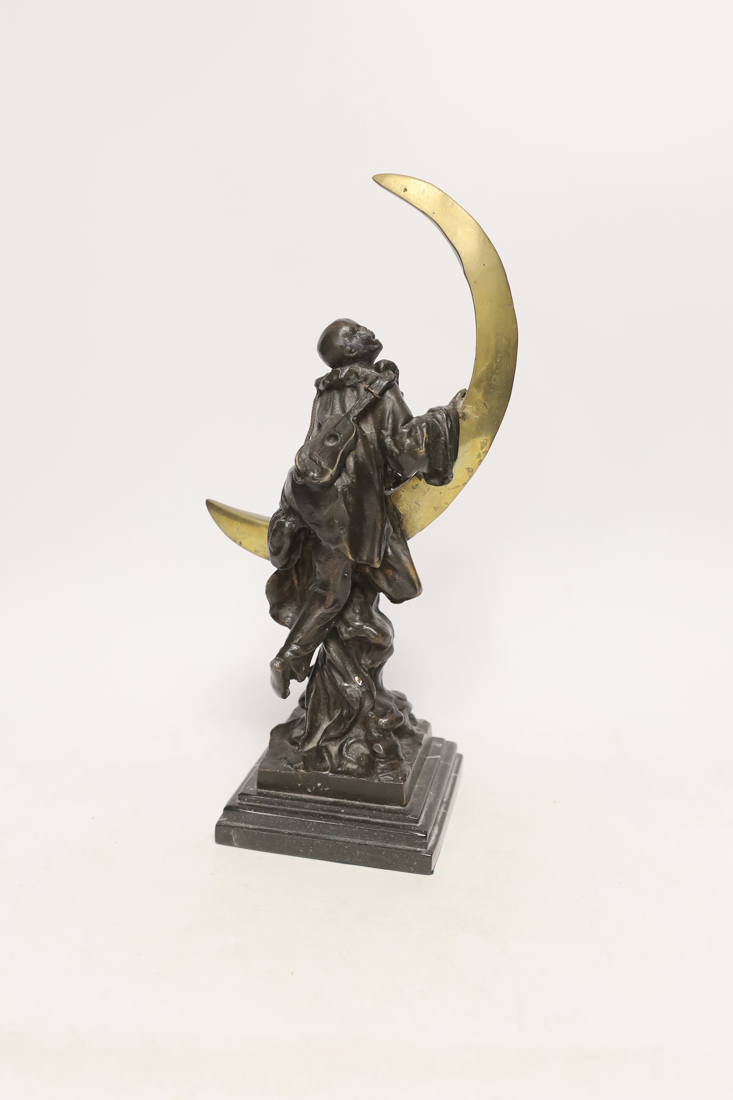 After Claire Colinet (1885-1972), a bronze study of a Pierrot and crescent moon, raised on stepped marble base, 33cm high